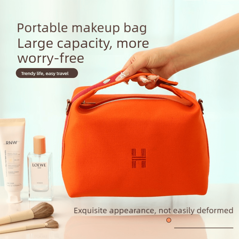 Large capacity orange makeup bag held by top handle